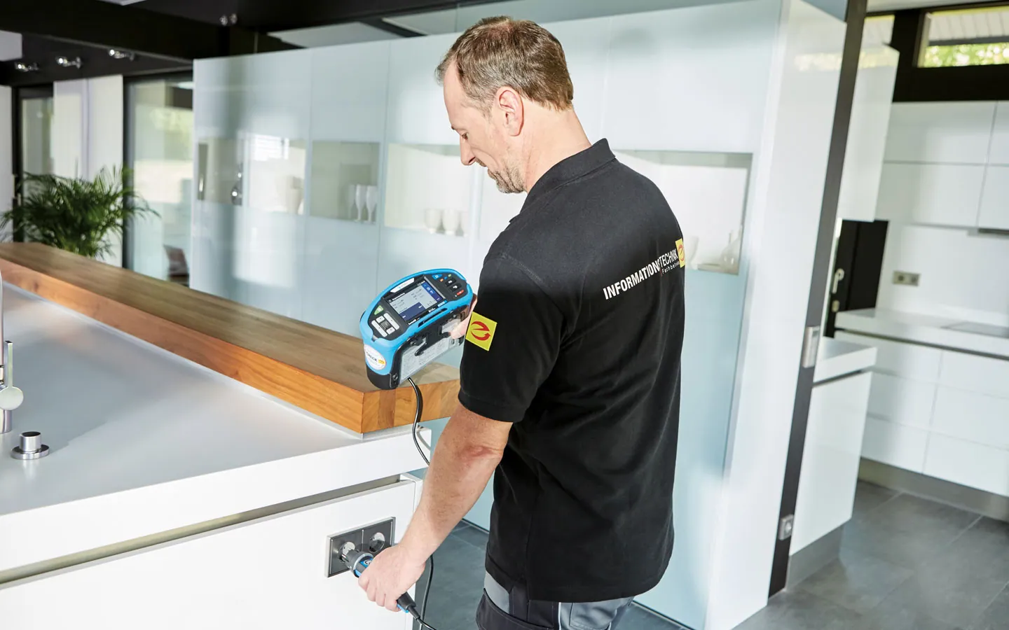 E-CHECK - Mitarbeiter prüft die Steckdosen in der Küche · Elektro Dörr