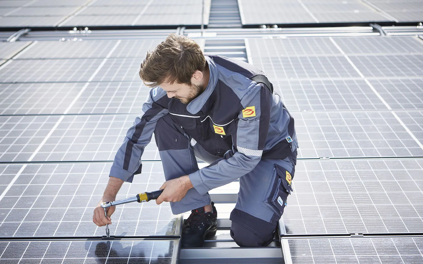 E-CHECK E-Mobilität - Mitarbeiter montiert auf dem Dach die neuen Solarmodule · Elektro Dörr