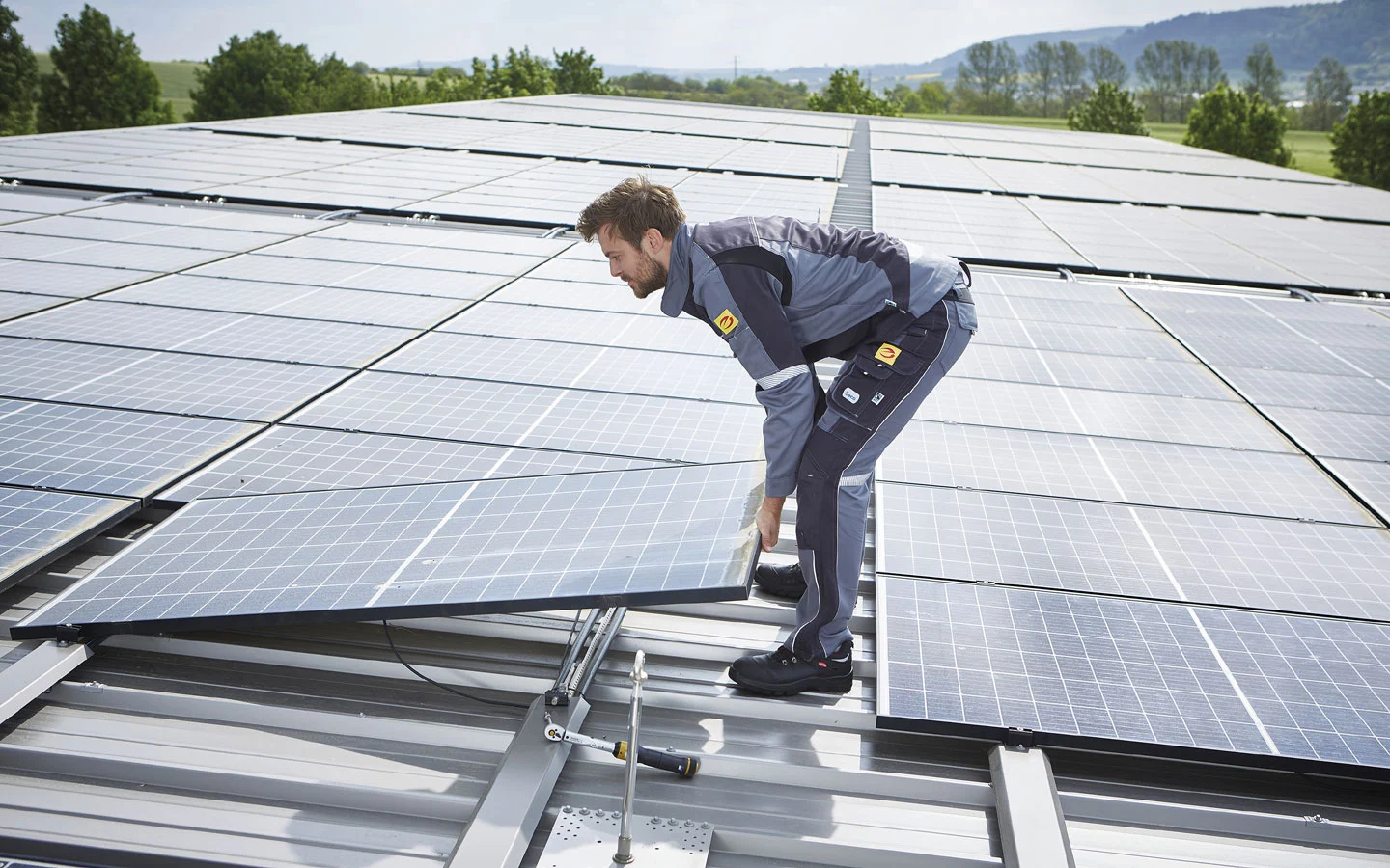 E-CHECK PV - Mitarbeiter installiert Solarzellen auf dem Dach · Elektro Dörr