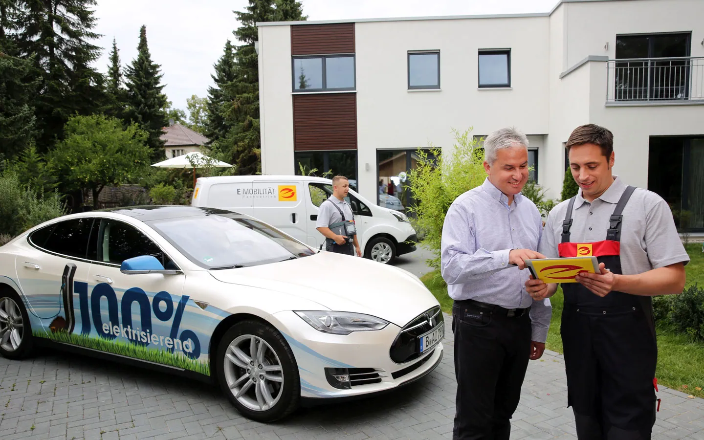 E-Mobilität - Mitarbeiter mit Kunden vor Elektrofahrzeugen 100% elektrisch · Elektro Dörr